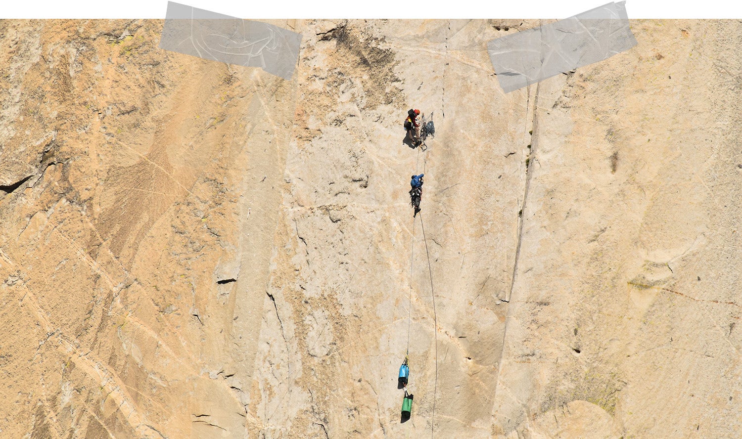 Long shot of Felipe and another climber ascending a vast golden rockface which takes up the entire frame.