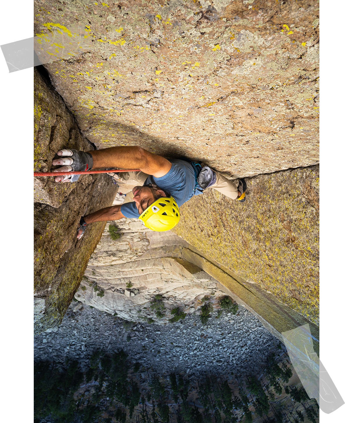 Photo of Erik climbing taken from above, with the rock-scattered ground stretching out far below. He looks calm but focused. 