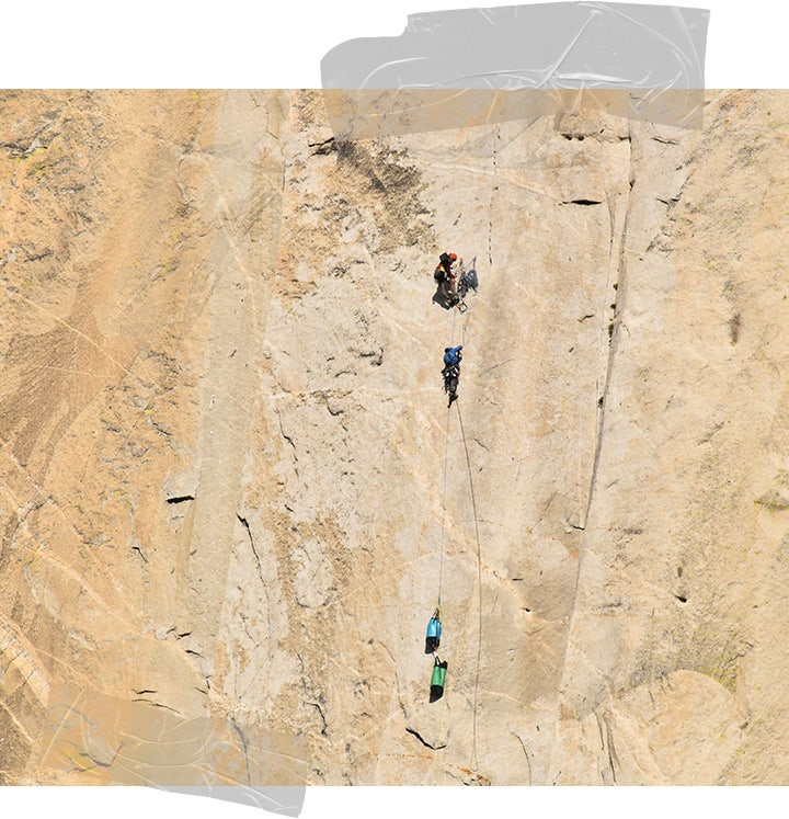 Long shot of Felipe and another climber ascending a vast golden rockface which takes up the entire frame.